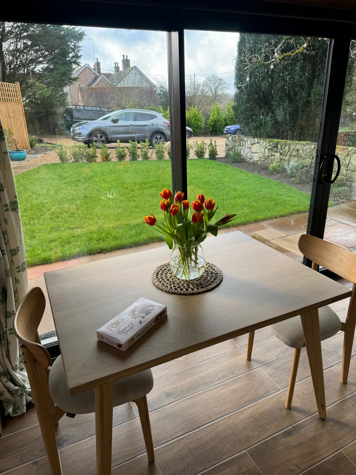 Dining table beside the glazed doors, looking out over the new lawn and garden