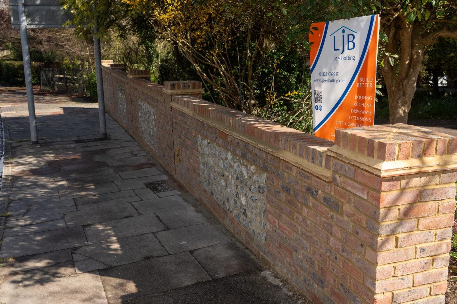 Completed brick and flint wall with new coping and piers