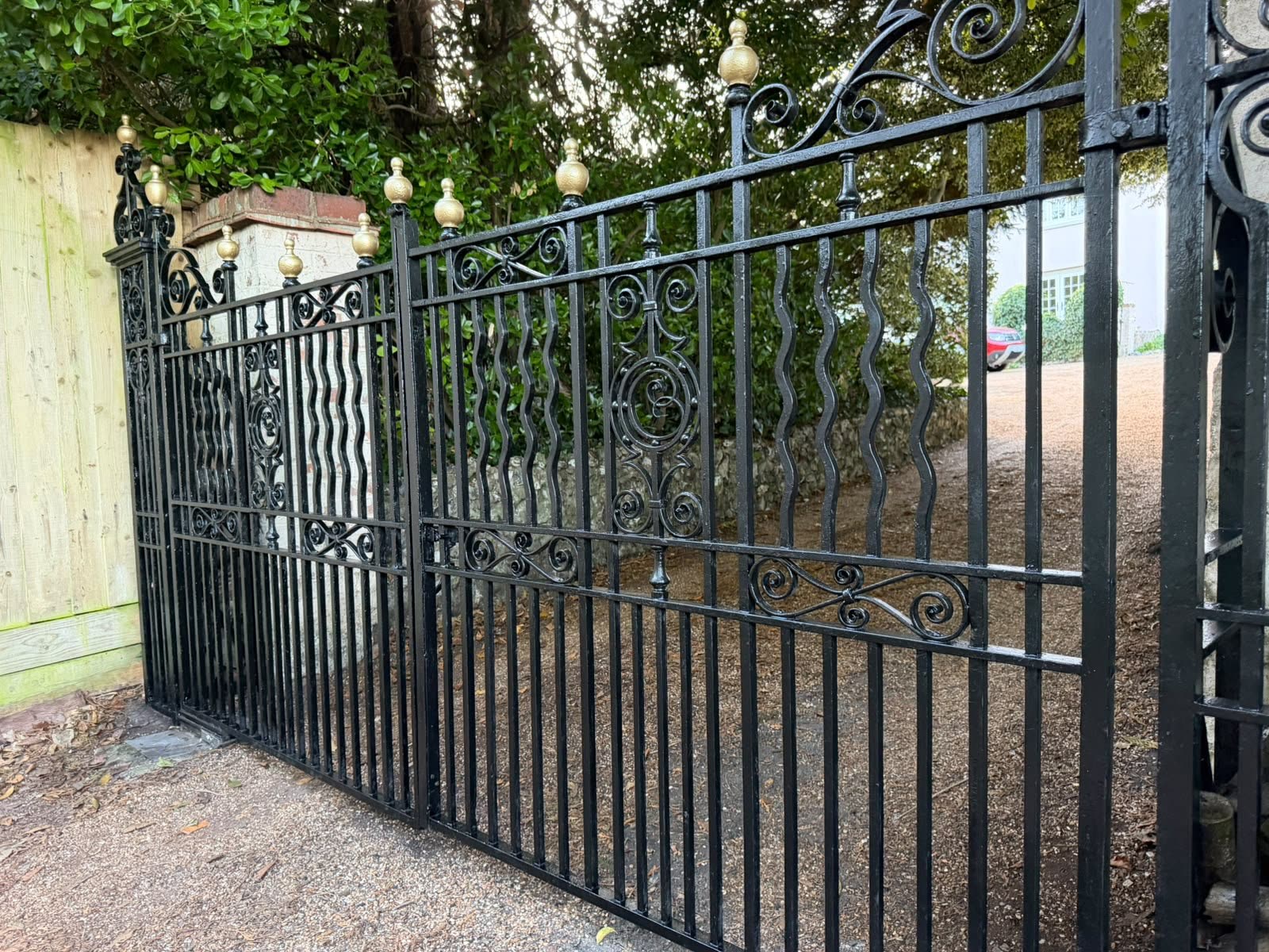 Restored wrought-iron driveway gate and entrance detail