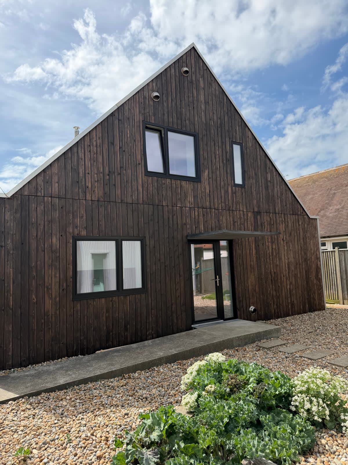 Contemporary black timber-clad outbuilding with fitted windows and doors