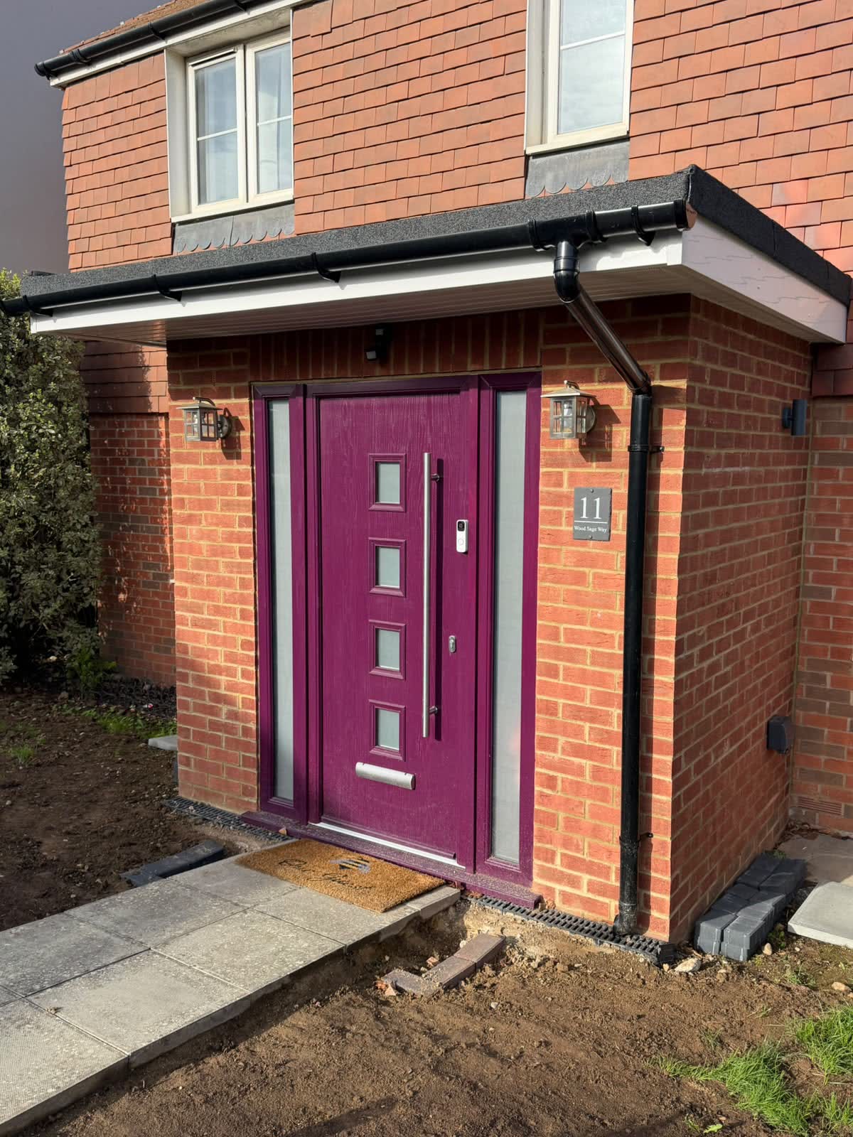 New brick porch with a purple composite front door