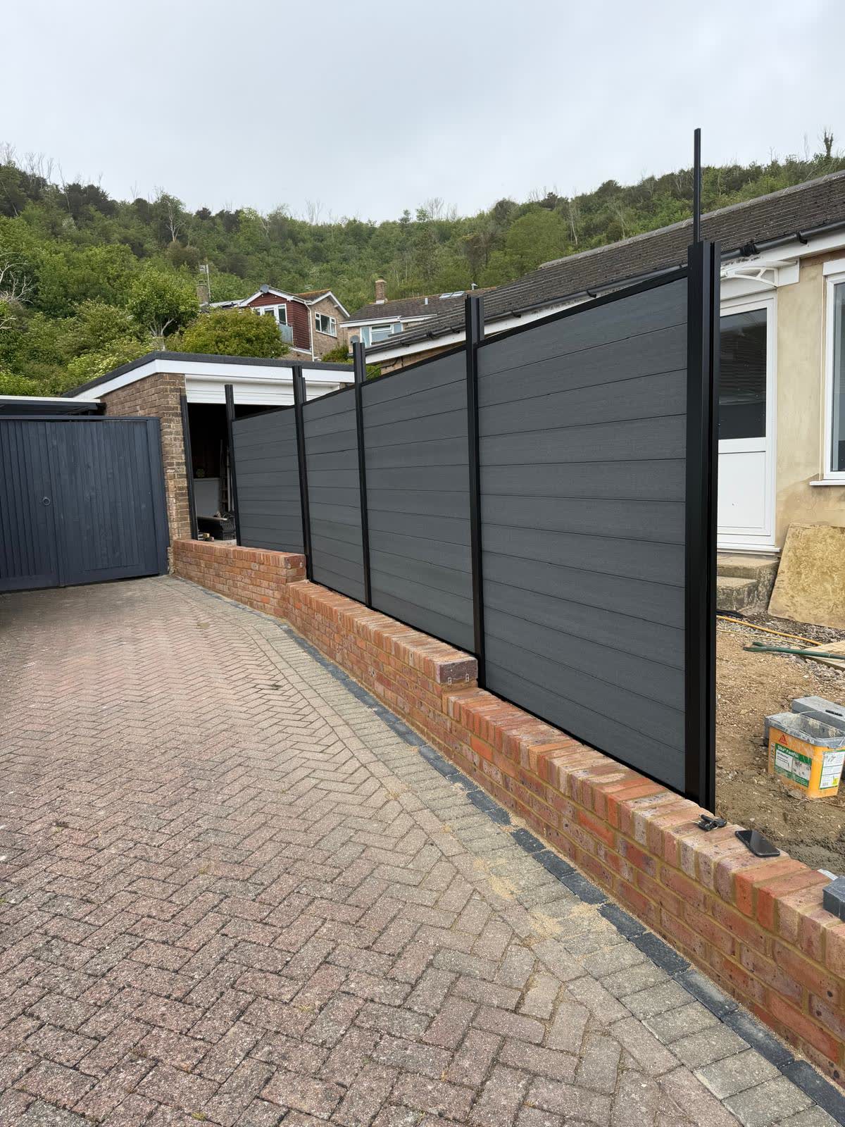 Low-maintenance composite boundary fencing on a brick base