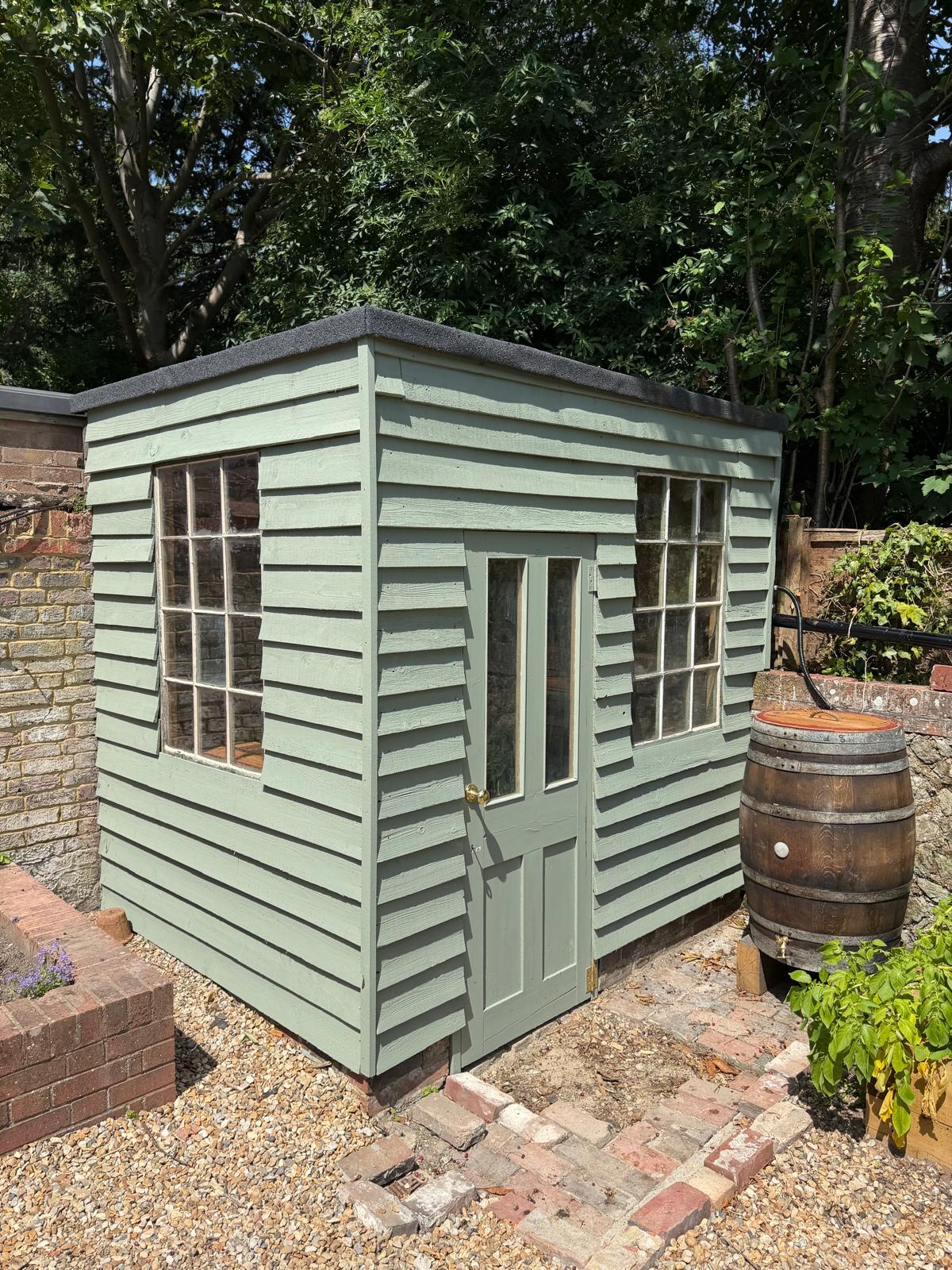 Painted timber garden room with glazed doors and traditional windows