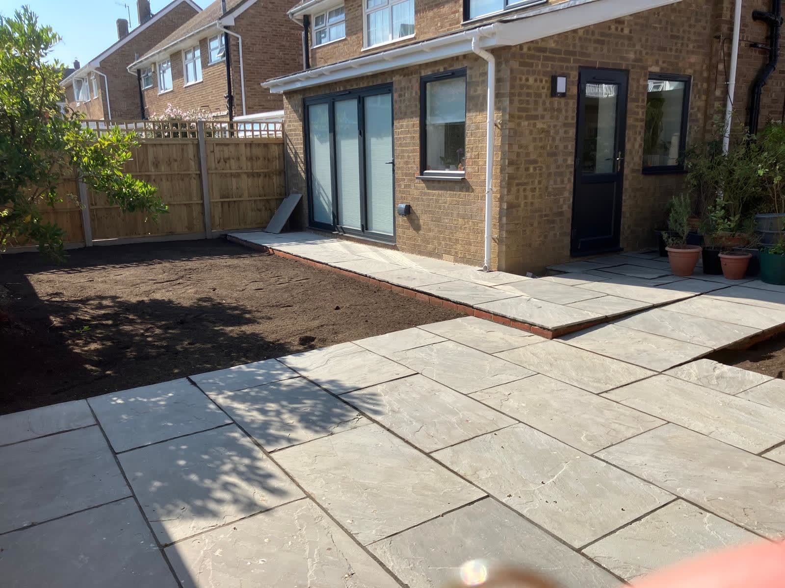 Large paved patio beside a completed rear extension