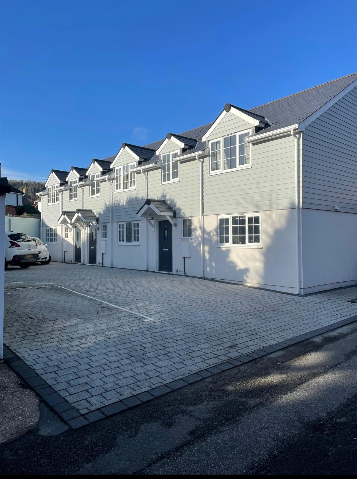 Renovated property exterior with a large block-paved driveway