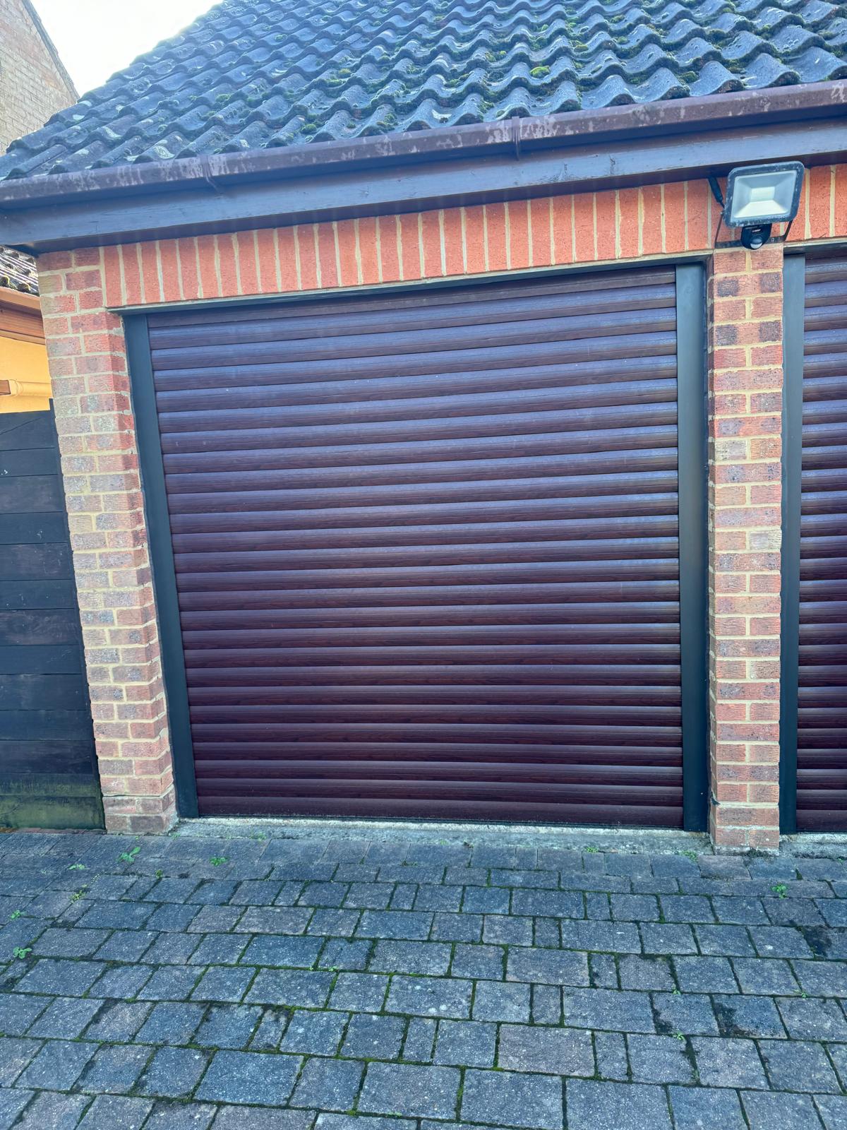 Roller garage door fitted between brick piers