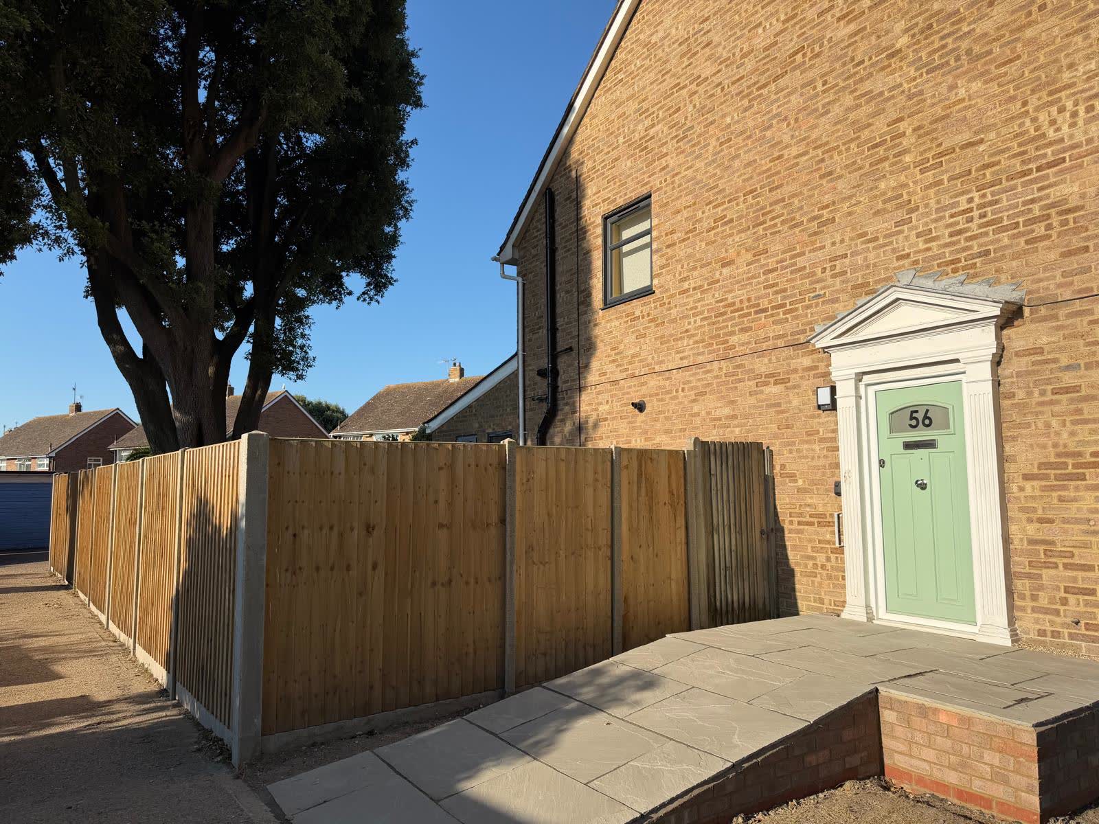 Contemporary slatted boundary fence above a brick base